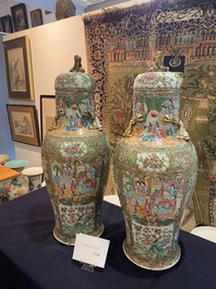 A pair of Chinese baluster shaped Canton famille rose vases with palace scenes and floral design, 19th C.