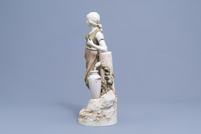 A polychrome decorated biscuit figure of a lady at a well, Royal Dux, 20th C.