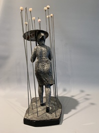 A patinated iron figure of a lady with an umbrella walking through the rain, 20th C.