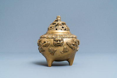 A Chinese bronze relief decorated tripod censer and cover, 19th/20th C.