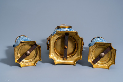 A Chinese three-piece gilt brass mounted clock garniture with blue and white vases with floral design, 19th C.