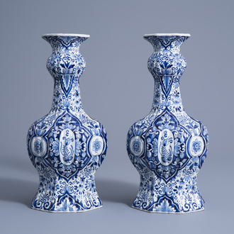 A pair of Dutch Delft blue and white garlic-head mouth vases with floral design, Makkum, 19th C.