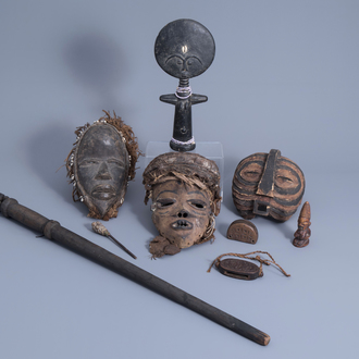 Three African wooden masks, votive objects and a cane, 20th C.