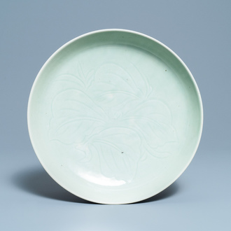A Chinese monochrome celadon glazed charger with underglaze floral design, 18th/19th C.