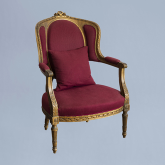 Un fauteuil de style Louis XVI en bois doré et revêtement en tissu rouge, 19ème/20ème siècle