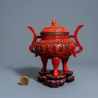 A Chinese imitation lacquer tripod incense burner and cover on a wooden base and a 'Buddhist symbols' amulet, 20th C.