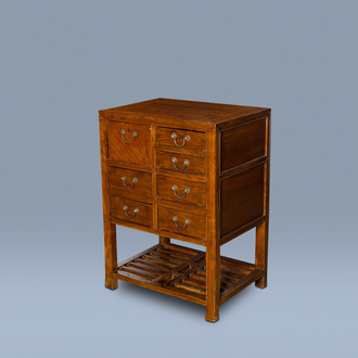 A Chinese wood side table with seven drawers, 19th/20th C.