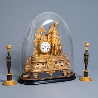 A French gilt zamac 'Diana' mantel clock with accompanying bell jar and a pair of patinated and bronze 'caryatid' candle sticks, 19th/20th C.