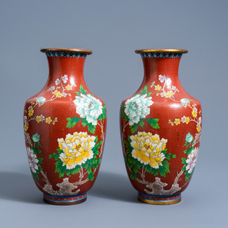 A pair of Chinese red ground cloisonné vases with a bird among blossoming branches, 20th C.
