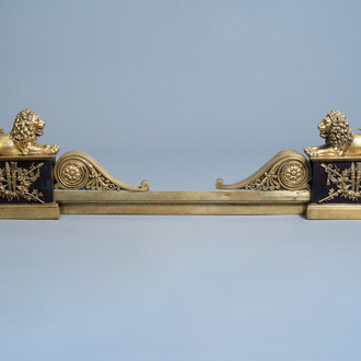 A pair of French Neoclassical patinated and gilt bronze andirons with a lion, 19th C.