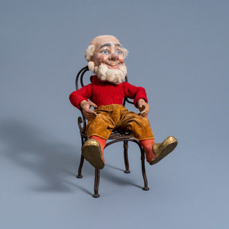 A paper mache and wooden gnome on a wrought iron chair, possibly Germany, 20th C.