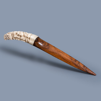 A Congolese letter opener with a carved ivory handle with children playing and a hardwood blade, first quarter of the 20th C.