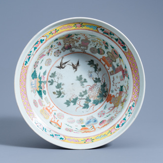 A Chinese famille rose bowl with birds among blossoming branches and antiquities, 19th C.