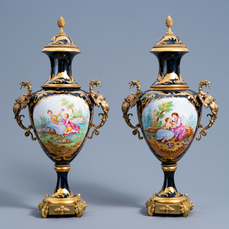 A pair of French gilt bronze mounted gold layered blue ground Sèvres style vases and covers with a love scene, 20th C.