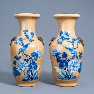 A pair of Chinese Nanking crackle glazed blue and white 'café au lait' ground vases with a bird on a blossoming branch, 19th C.