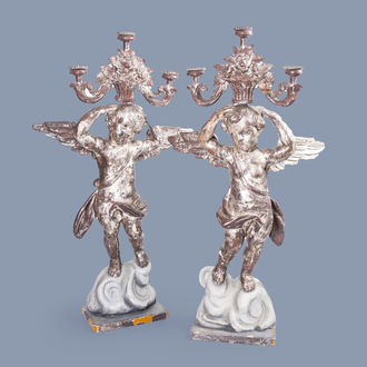 A pair of imposing Italian carved, polychrome painted and silver-plated wood angel shaped candlesticks, 18th C.