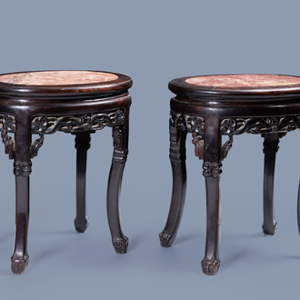 A pair of oval Chinese carved wood stands with marble top, 19th/20th C.