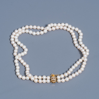 A necklace with white pearls set with four diamonds and an 18 carat yellow gold clasp, 20th C.