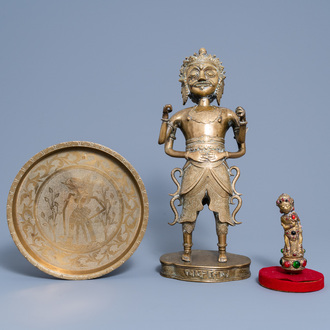 An Indonesian brass alloy figure of a deity, an embellished kris handle and an engraved charger on foot, 19th/20th C.