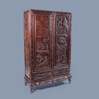 A Chinese richly carved wood two-door cabinet with figures in a landscape and faux-bamboo design, Republic, 20th C.
