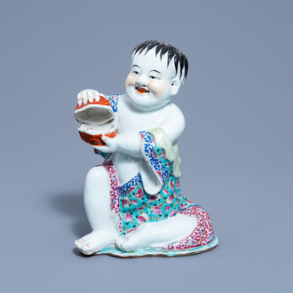 A Chinese famille rose figure of a boy holding a box and cover in his hands, 19th/20th C.