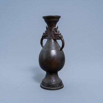 A Chinese bronze vase with handles in the shape of mythical animal heads, Ming