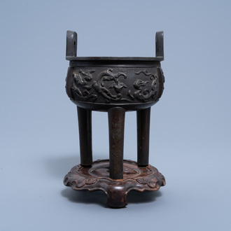 A Chinese bronze tripod censer on wood stand, Qing