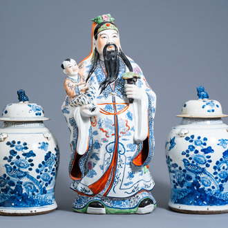A pair of Chinese blue and white vases and covers with birds among blossoming branches and a 'Star god' figure, 20th C.