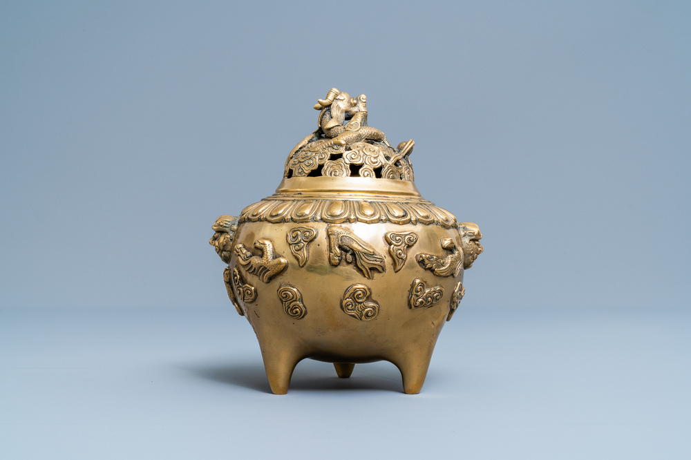 A Chinese bronze relief decorated tripod censer and cover, 19th/20th C.